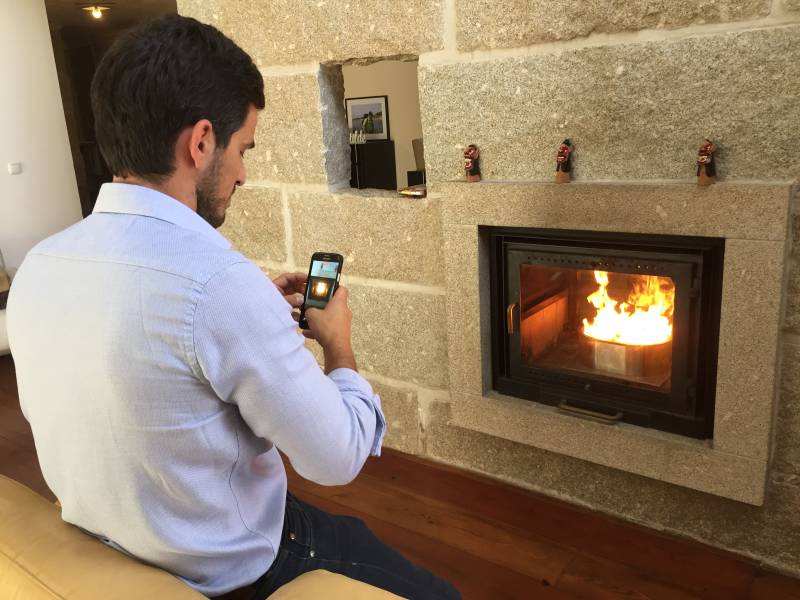 Profesionnal controlling heat temperature provided by QAÏTO pellet burner in a fireplace with heat accumulation firestones